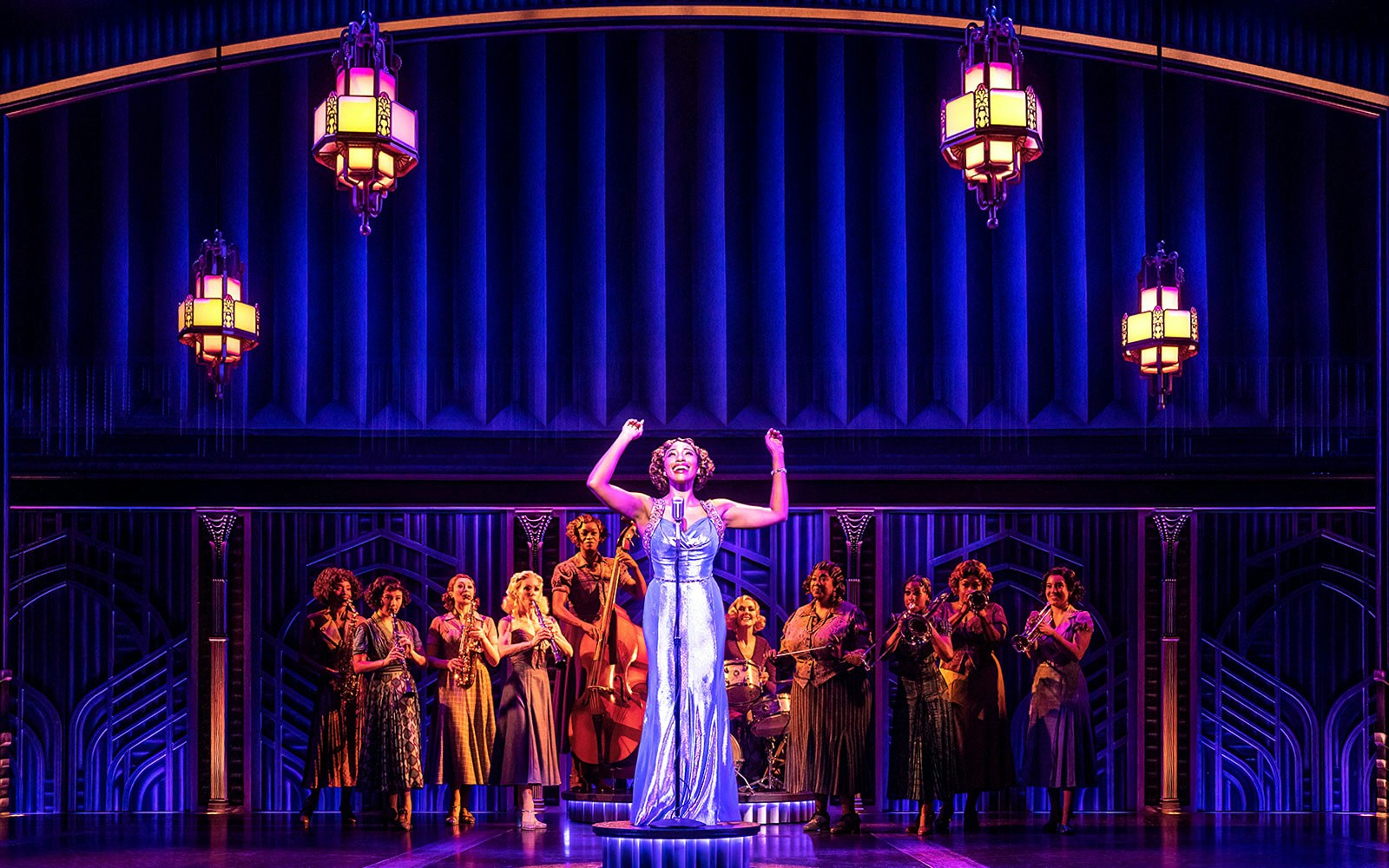 Performer on stage with musicians in "Some Like it Hot" musical.
