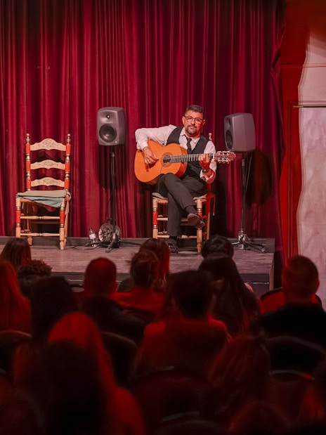Guitarist performing at Palau Dalmases Flamenco Show in Barcelona.