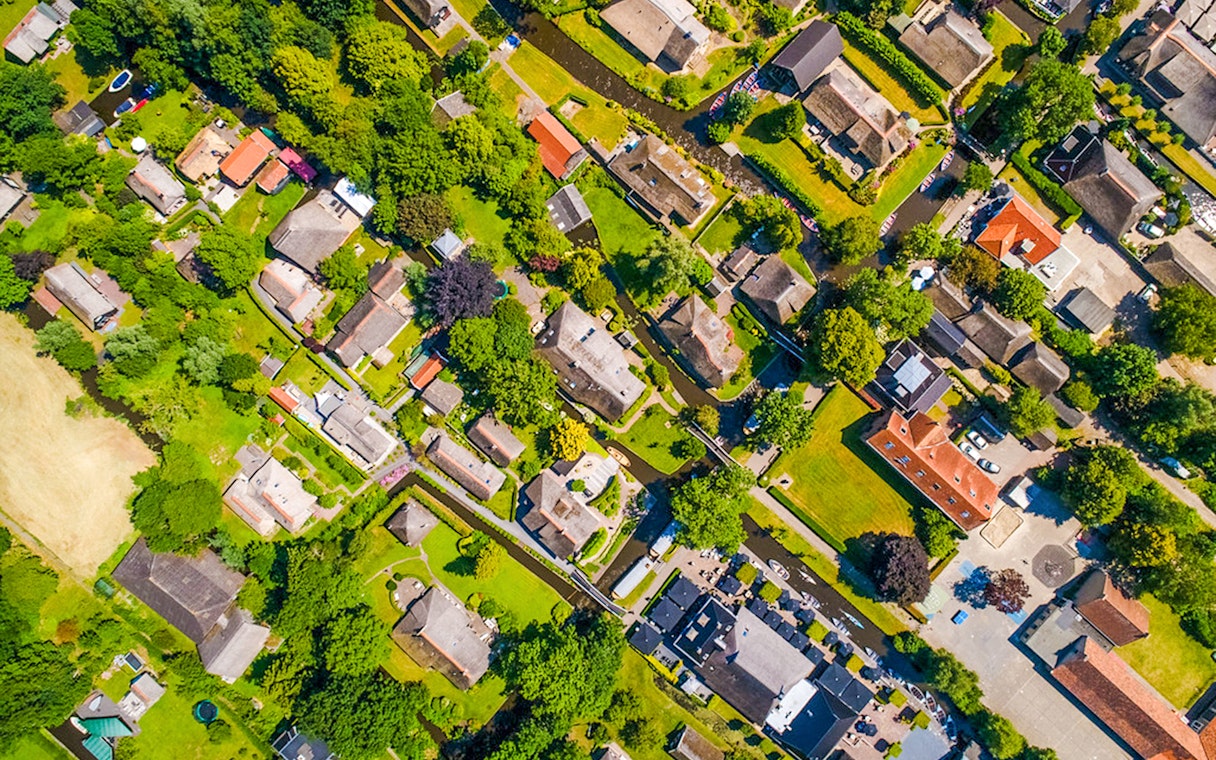 Aerial view of Giethoorn village with canals, green spaces, and traditional houses.