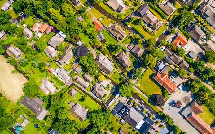 Aerial view of Giethoorn village with canals, green spaces, and traditional houses.