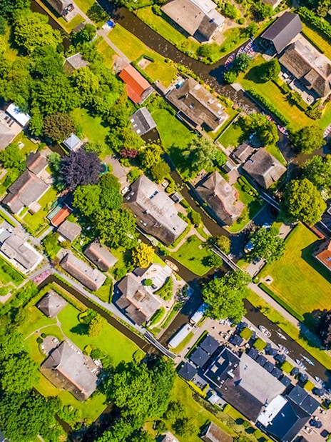 Aerial view of Giethoorn village with canals, green spaces, and traditional houses.