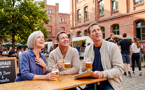 People enjoying beer at an outdoor table during Berlin Oktoberfest walking tour.
