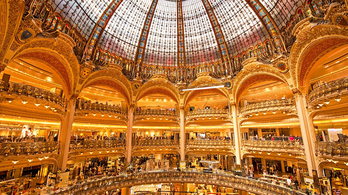 Galeries Lafayette interior with ornate glass dome and multiple shopping levels in Paris.