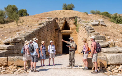 Tour group with guide at the entrance of the Tomb of Agamemnon, Mycenae, Greece.