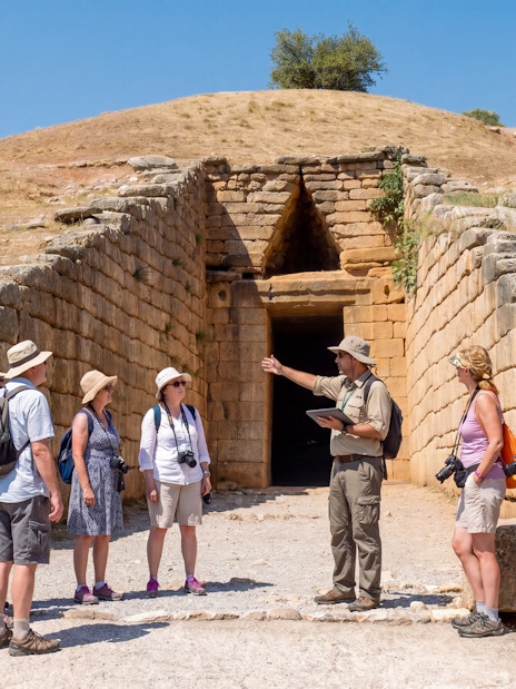 Tour group with guide at the entrance of the Tomb of Agamemnon, Mycenae, Greece.