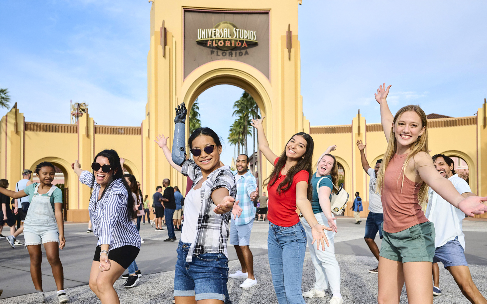 Guests posing at Universal Studios entrance arch, Universal Studios Resort, Orlando.