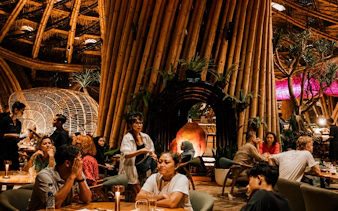 Guests enjoying dining at Luna Beach Club with bamboo architecture.