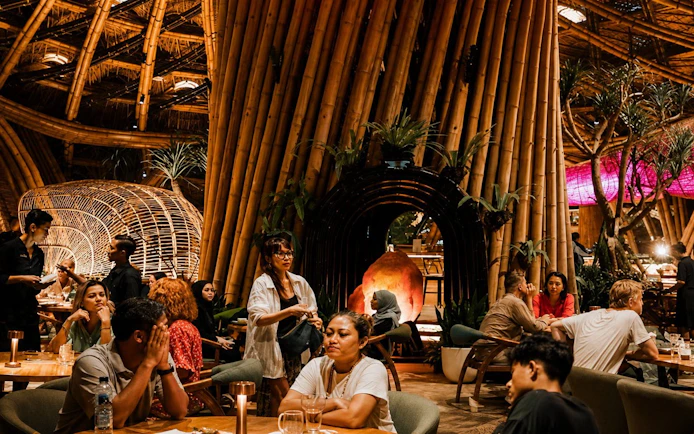 Guests enjoying dining at Luna Beach Club with bamboo architecture.