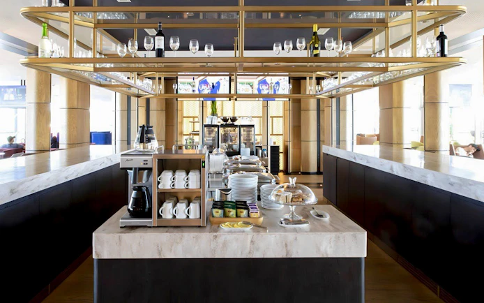 Primeclass Lounge Zurich Airport Terminal E coffee station with cups and snacks.