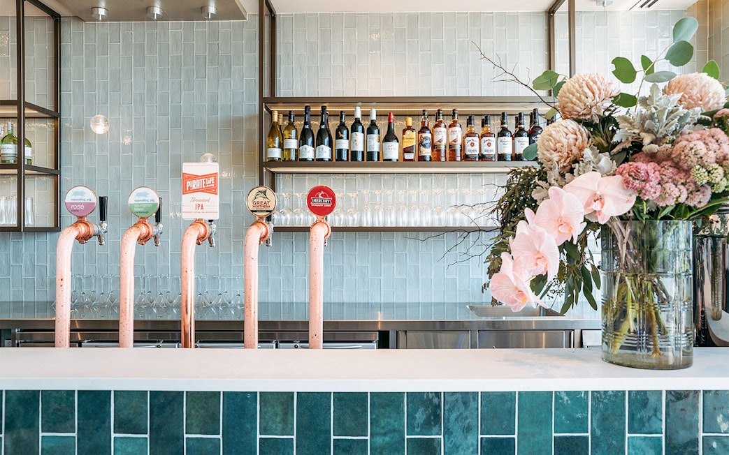 Bar area with beer taps and floral arrangement at Plaza Premium Lounge, International Arrival.