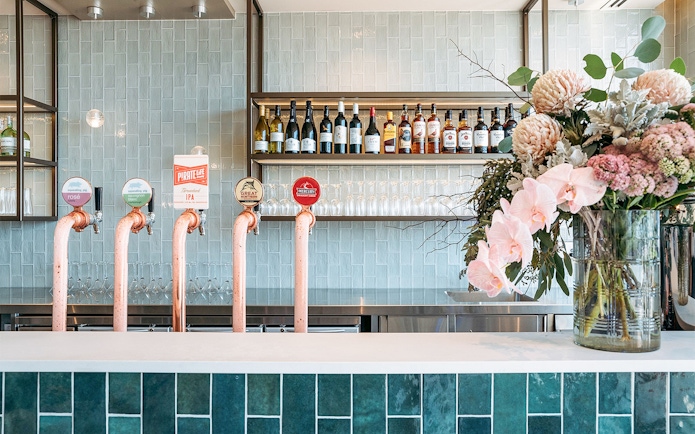 Bar area with beer taps and floral arrangement at Plaza Premium Lounge, International Arrival.