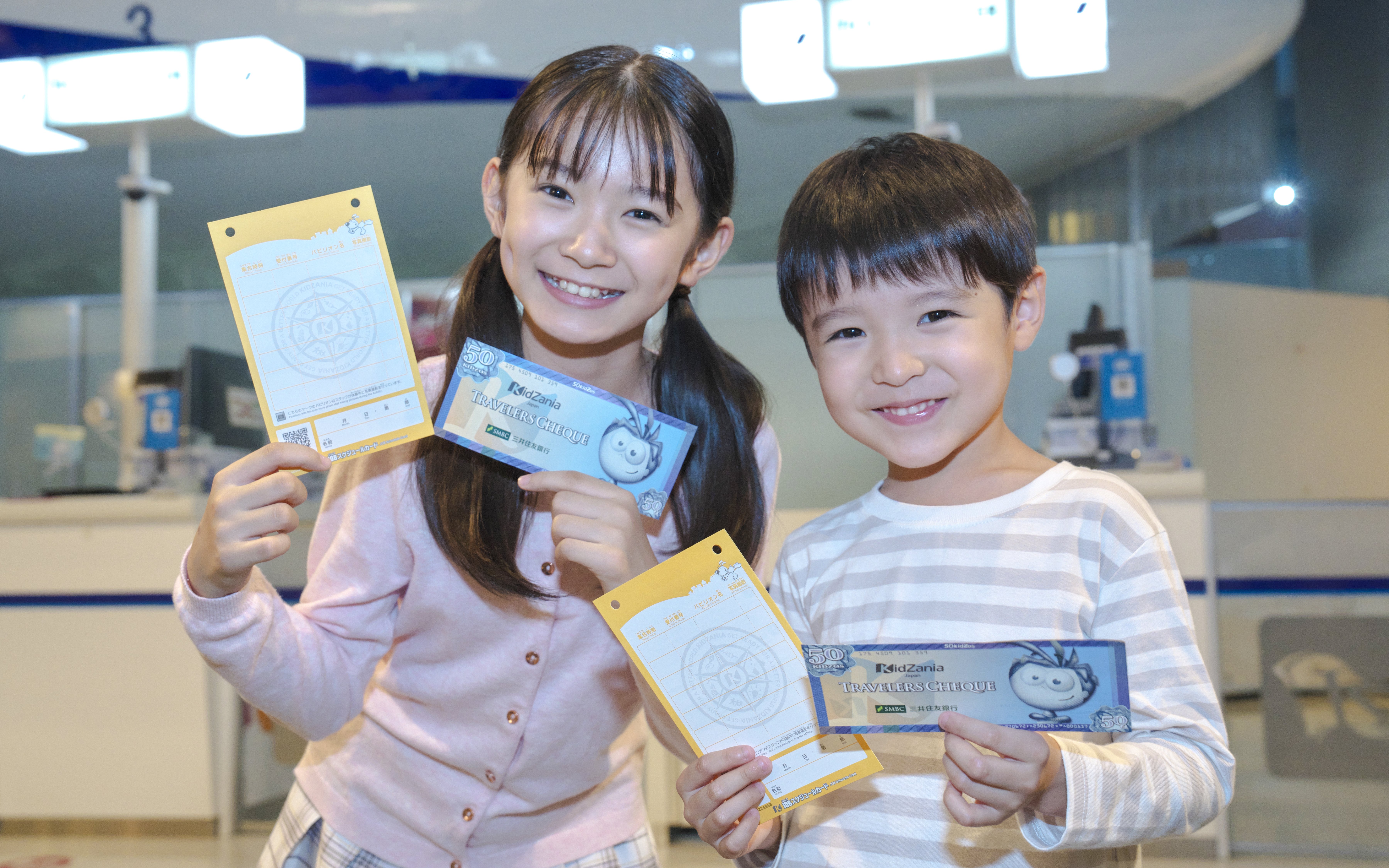 Children holding certificates at KidZania Tokyo ceremony.