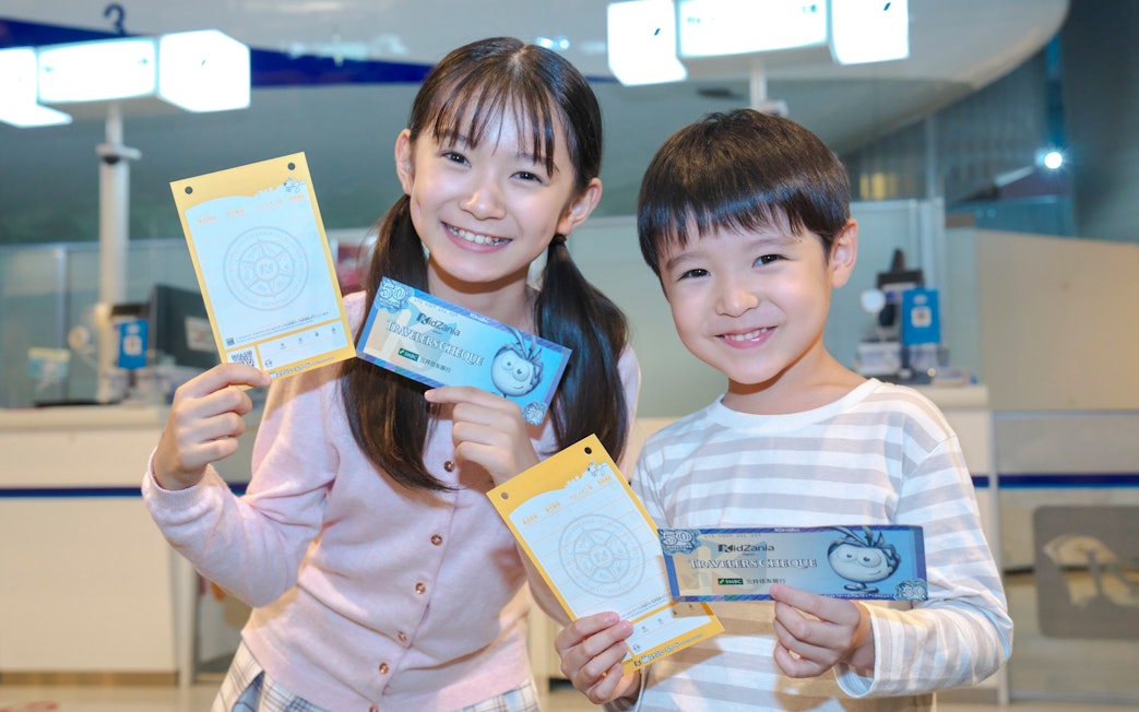 Children holding certificates at KidZania Tokyo ceremony.