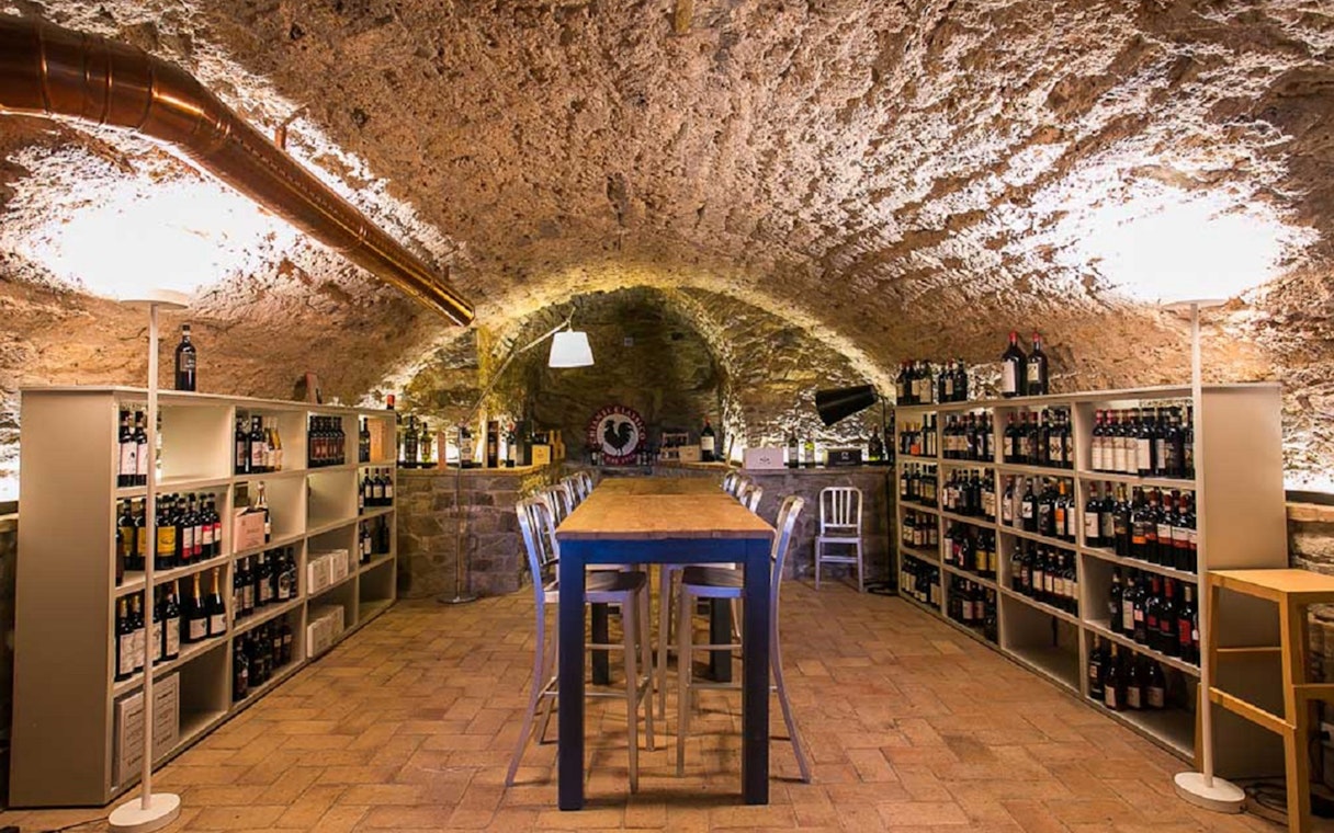 Wine cellar with tasting table and shelves of wine bottles in Chianti Hills.