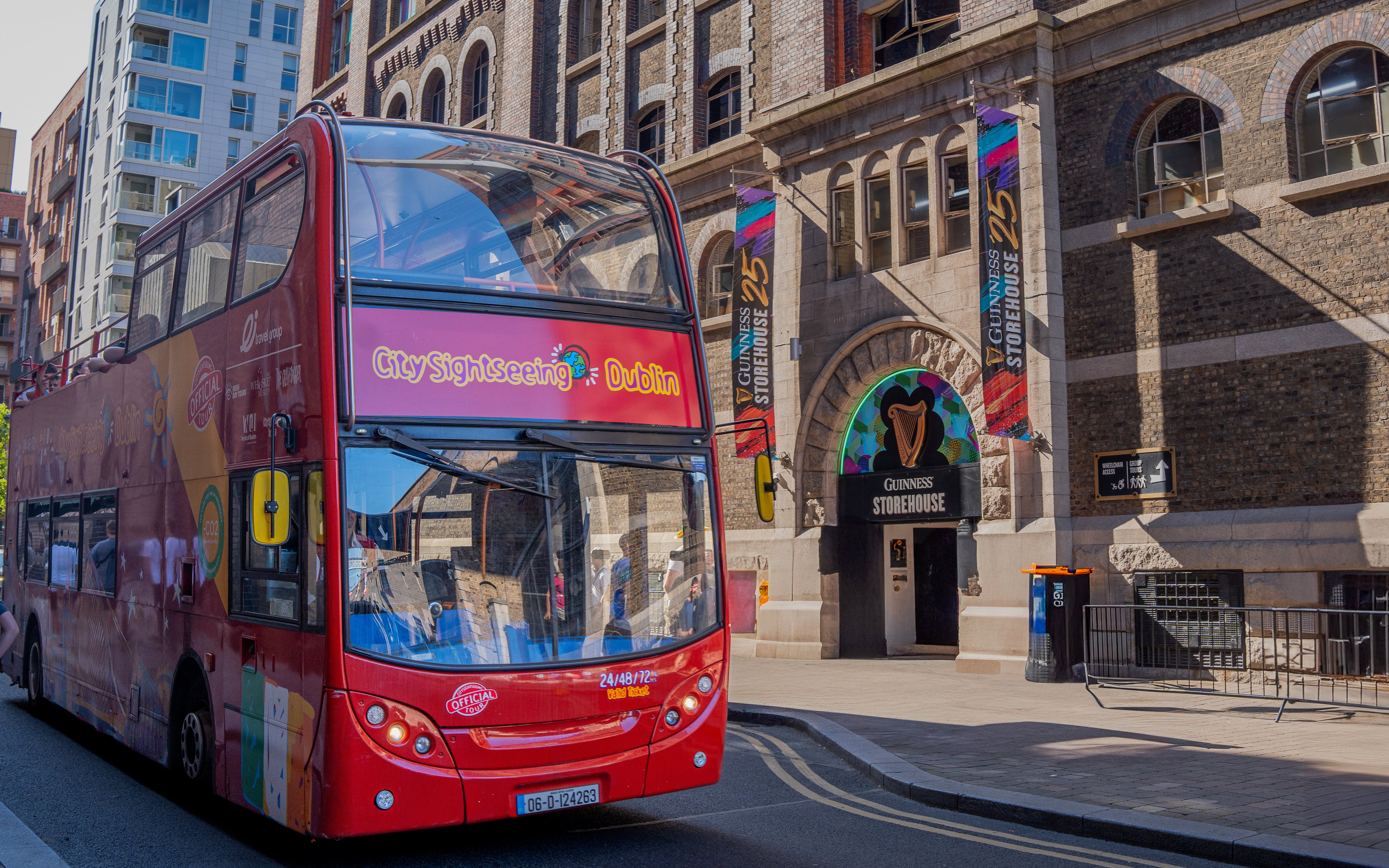 Open-top tour bus in Dublin near Guinness Storehouse entrance.