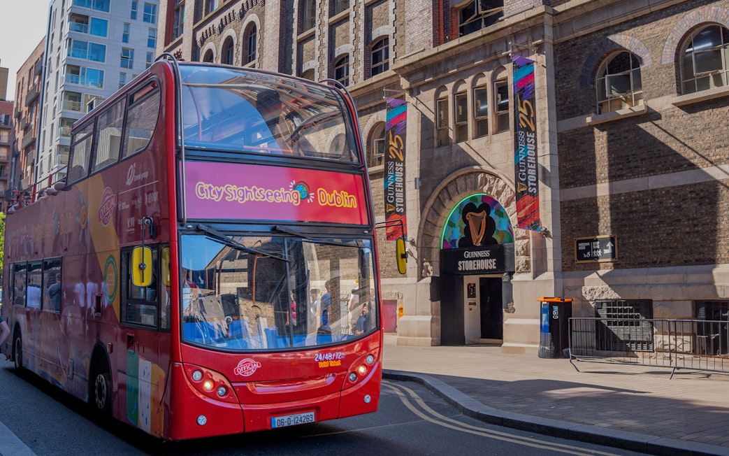 Open-top tour bus in Dublin near Guinness Storehouse entrance.
