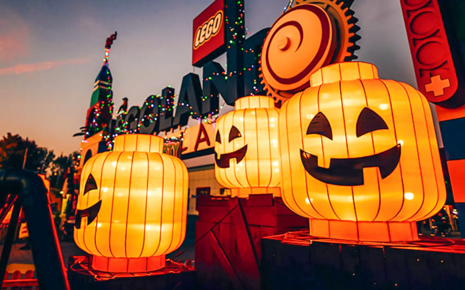 Glowing pumpkin lanterns at Legoland Billund entrance during Halloween event.