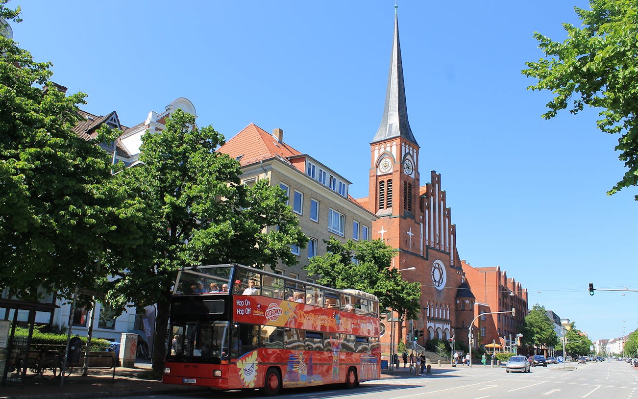 Hop-on hop-off bus near St. Nikolai Church in Kiel, Germany.