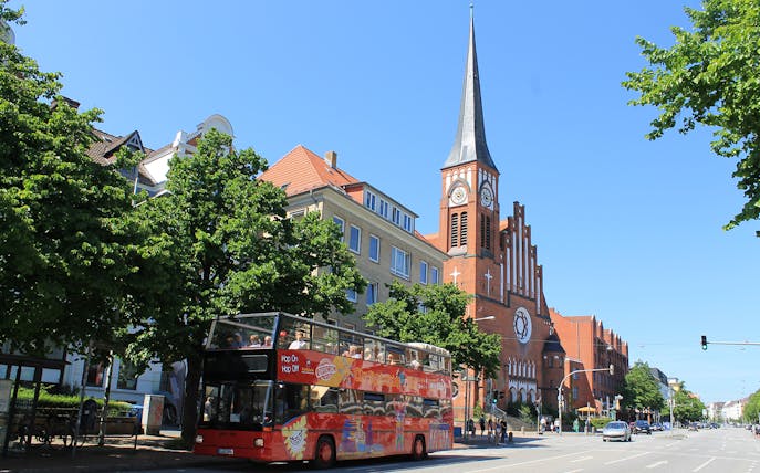 Hop-on hop-off bus near St. Nikolai Church in Kiel, Germany.