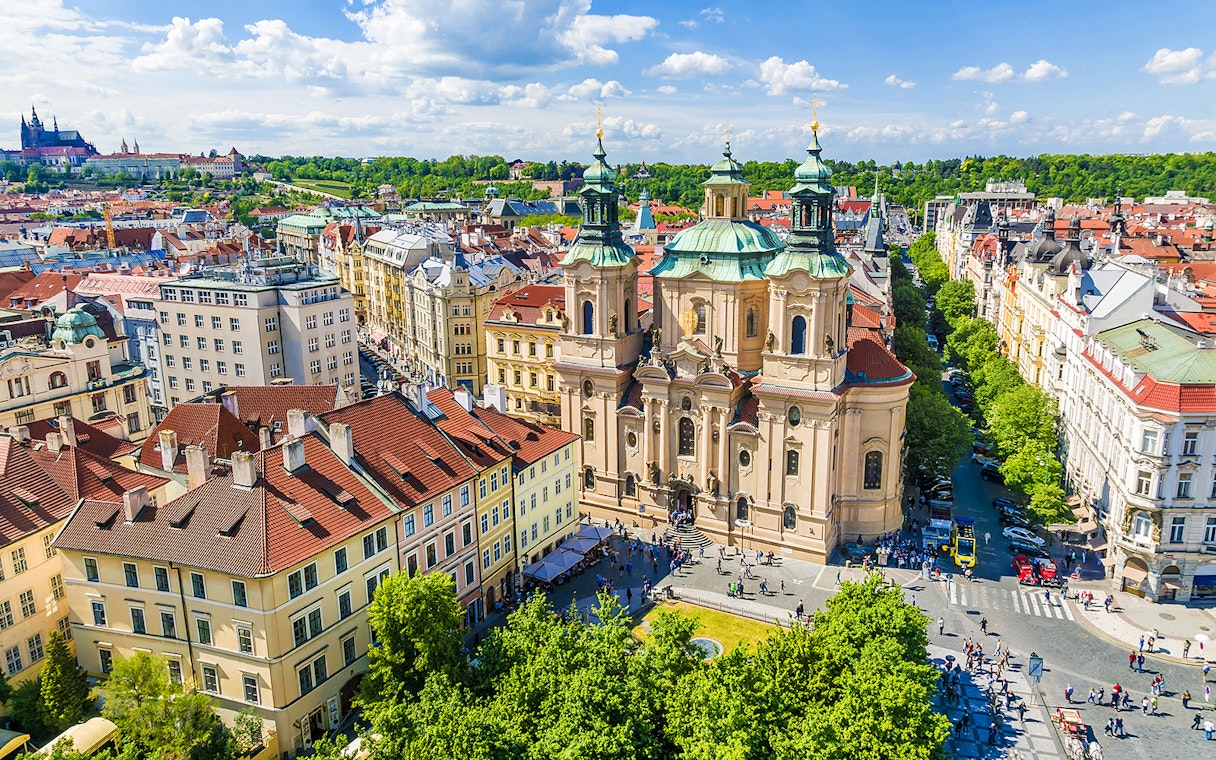 St. Nicholas Church in Prague with surrounding cityscape.