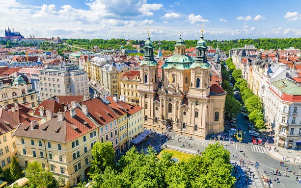 St. Nicholas Church in Prague with surrounding cityscape.