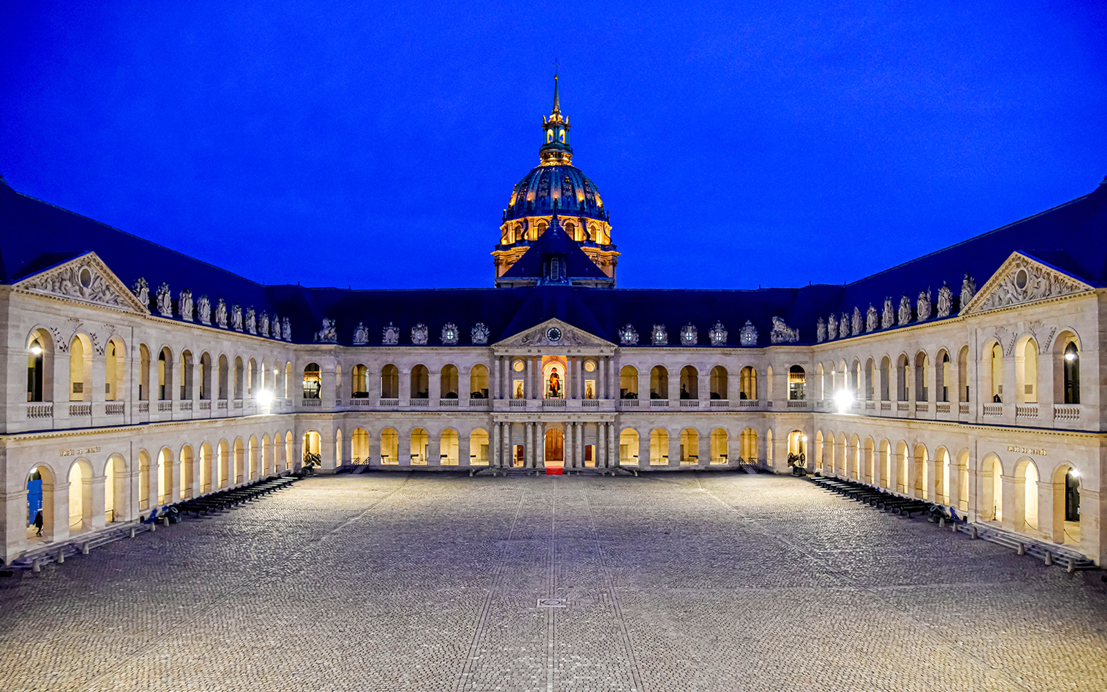 Courtyard of the Army Museum at Les Invalides, Paris, illuminated at night.
