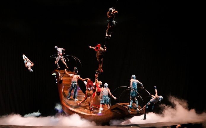 Acrobats performing on a rotating platform in Cirque du Soleil KÀ show.