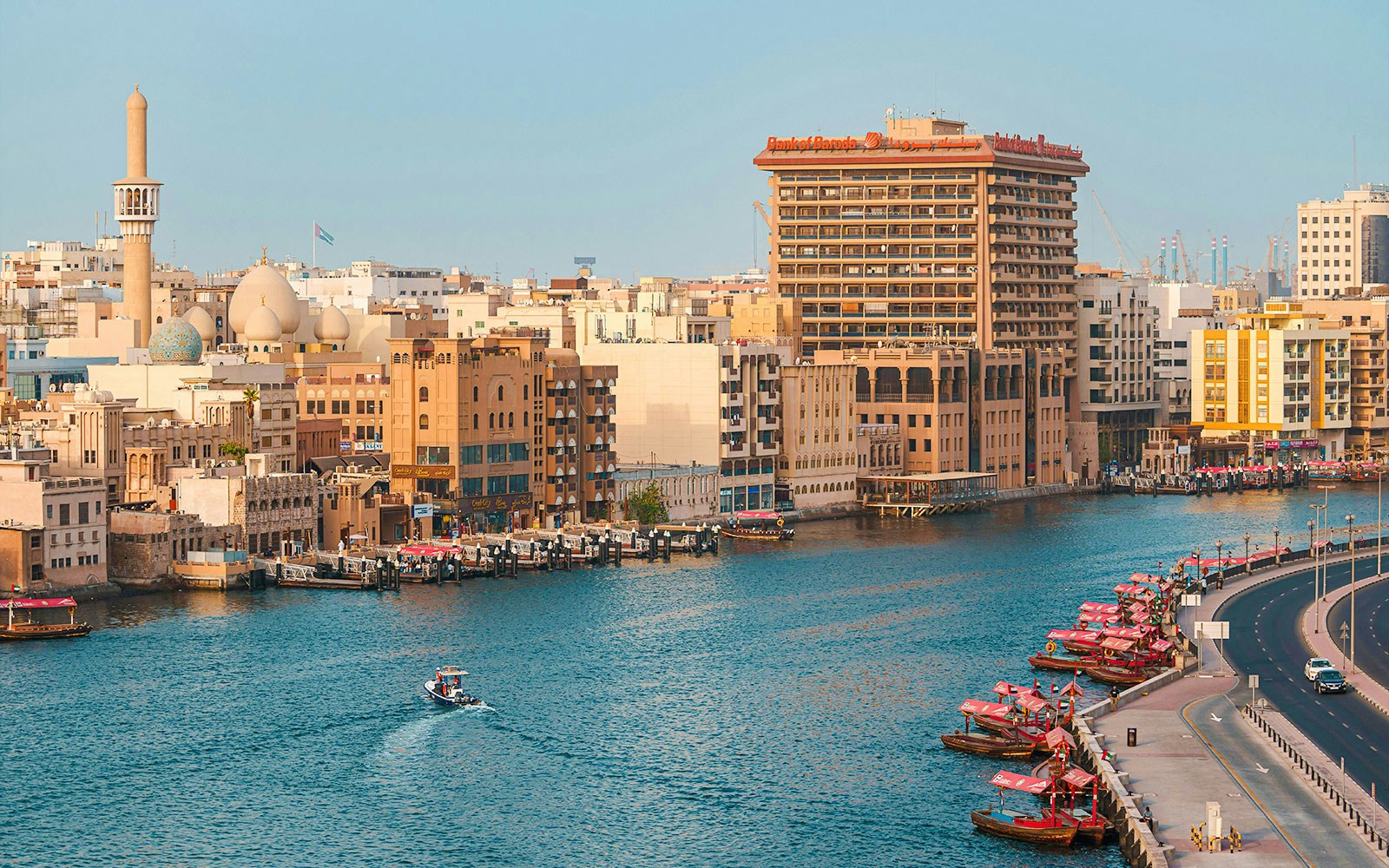 Dubai Creek with traditional boats and city skyline in the background.