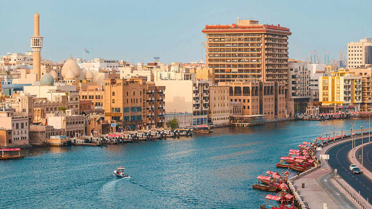 Dubai Creek with traditional boats and city skyline in the background.