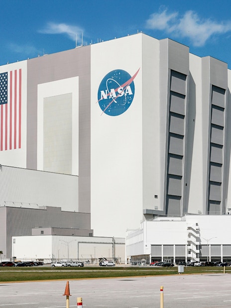 NASA Kennedy Space Center Vehicle Assembly Building with American flag and logo.