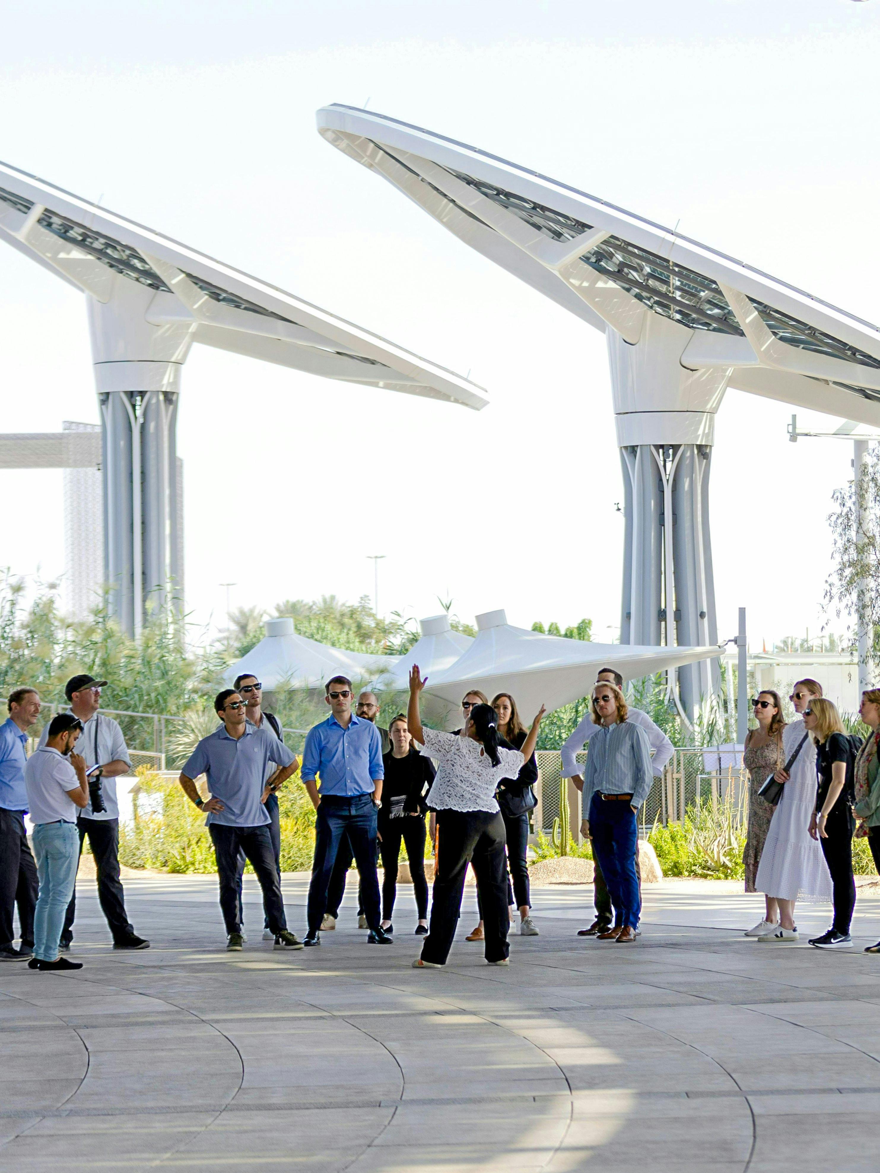 Guide engaging with tourists at Expo City Dubai pavilion.
