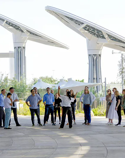 Guide engaging with tourists at Expo City Dubai pavilion.