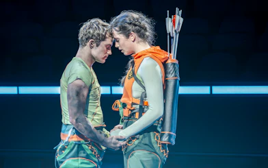 Actors in a tense moment during Hunger Games West End stage performance.