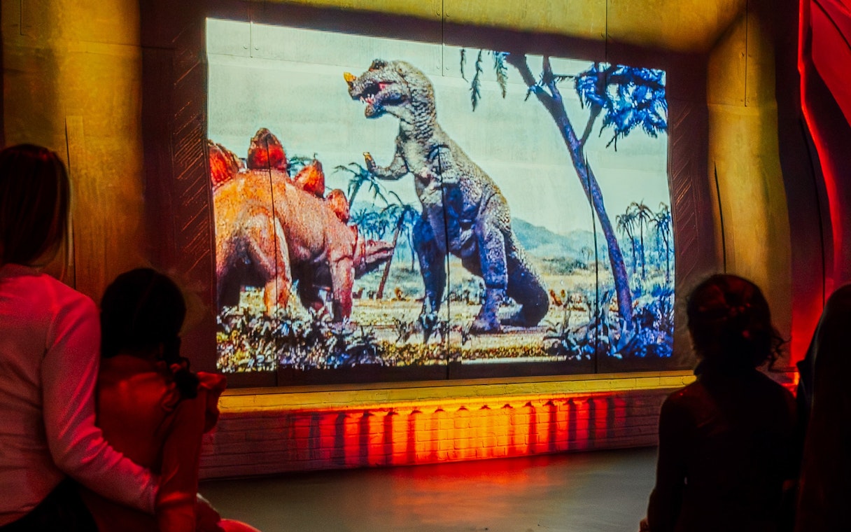 Visitors watching dinosaur projection at Prehistoric Planet: Dinosaurs – The Immersive Experience.