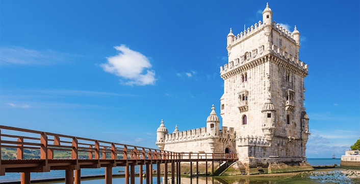 Belem Tower in Lisbon with nearby waterfront restaurants and scenic views.