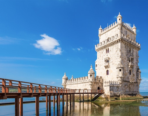 Belem Tower in Lisbon with nearby waterfront restaurants and scenic views.