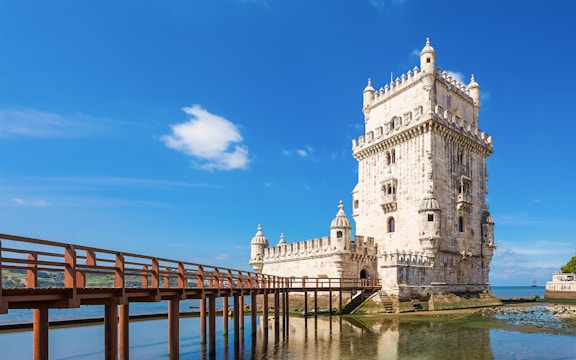 Belem Tower in Lisbon with nearby waterfront restaurants and scenic views.
