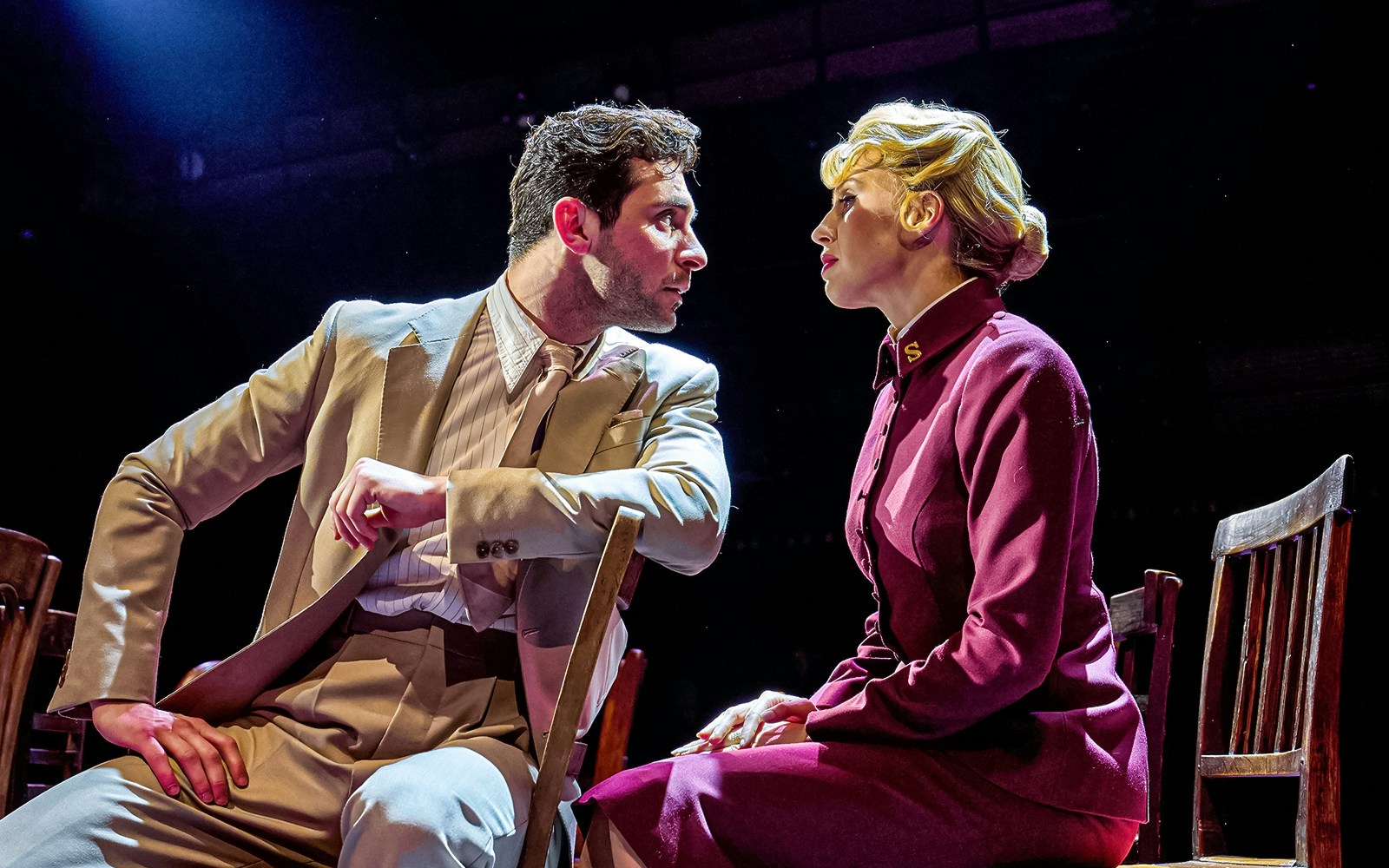 Actors in a dramatic scene from the musical "Guys & Dolls" on stage.