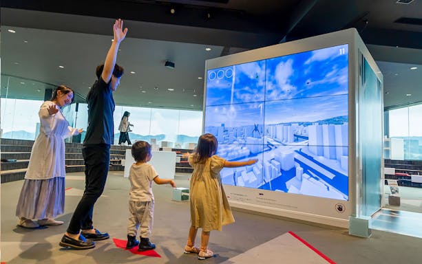 Visitors interacting with a digital display at Hiroshima Orizuru Tower.