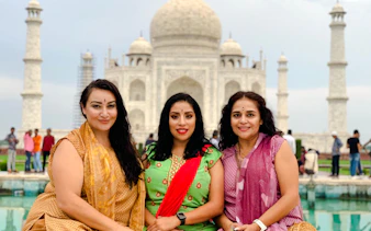 Visitors at the Taj Mahal, Agra, with the iconic marble mausoleum in the background.