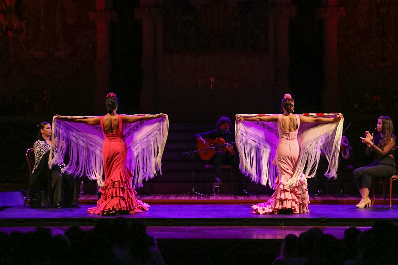 Flamenco dancers performing at Teatro EDP Gran Vía in Madrid with musicians on stage.
