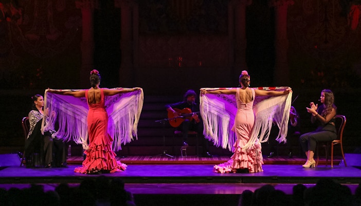 Flamenco dancers performing at Teatro EDP Gran Vía in Madrid with musicians on stage.