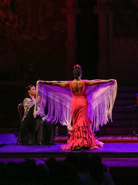 Flamenco dancers performing at Teatro EDP Gran Vía in Madrid with musicians on stage.