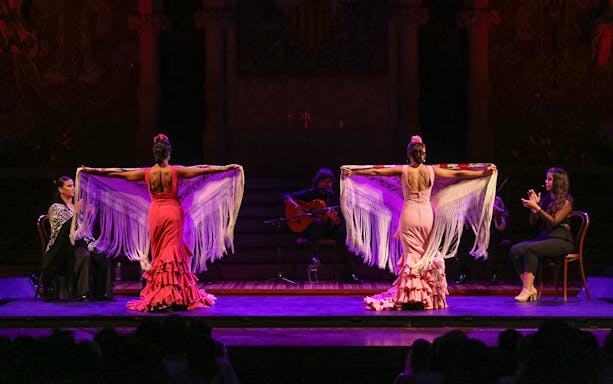 Flamenco dancers performing at Teatro EDP Gran Vía in Madrid with musicians on stage.