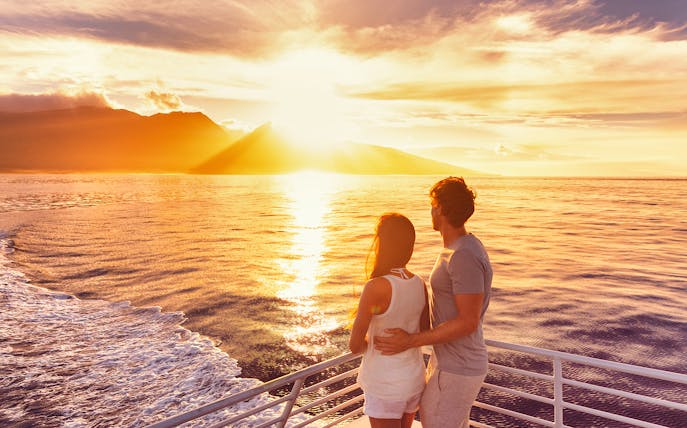 Couple enjoying sunset on Split Riviera cruise with drinks.