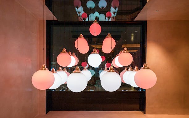 Hanging spherical lights in Flottille's snack & go setting.