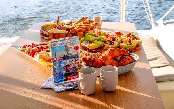 Breakfast spread on catamaran cruise from Gdansk with pastries, cheese, and coffee.