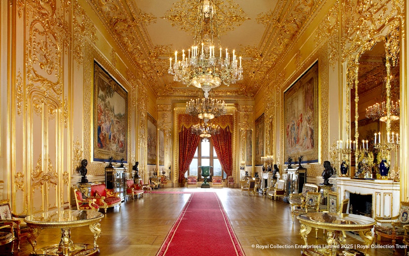 Windsor Castle interior with ornate chandeliers, gilded walls, and red carpet.