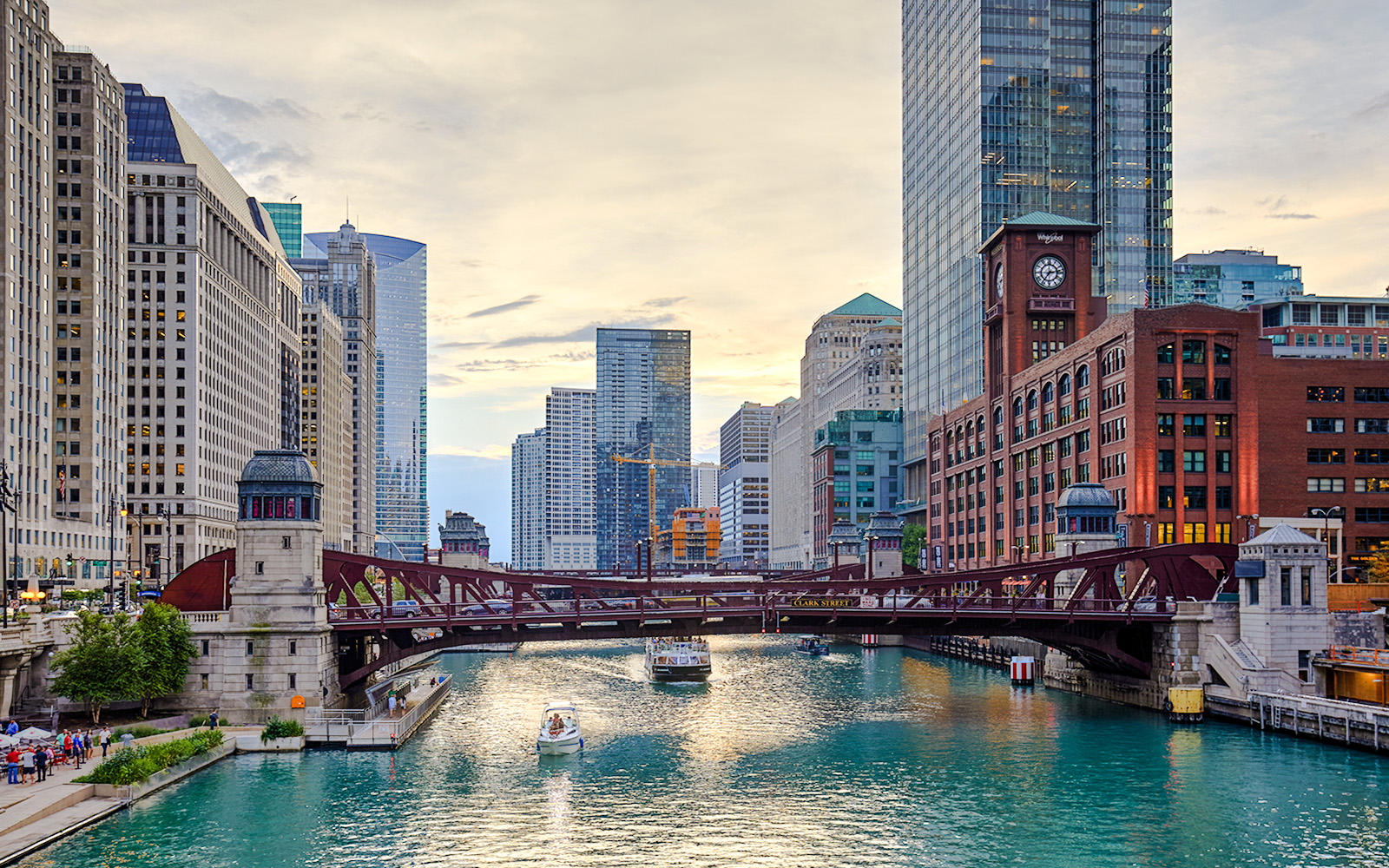 Chicago River with boats and iconic skyscrapers in downtown Chicago.
