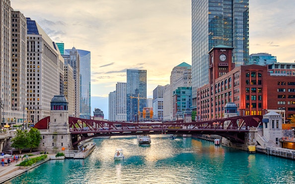 Chicago River with boats and iconic skyscrapers in downtown Chicago.